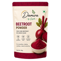 A 100g stand-up pouch of Damira by Gupta Beetroot Powder. The cream-colored packaging features a red top and bottom border, the brand logo, product name, and an illustration of a beetroot with a bowl of vibrant red powder.